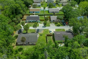 An aerial view of a residential area with houses, a street, and parked cars. - Bright Bay Hideaway • Springs • Pets Welcome (Crystal River)