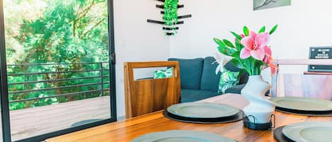 A dining area with a wooden table, plates, and a vase with flowers.