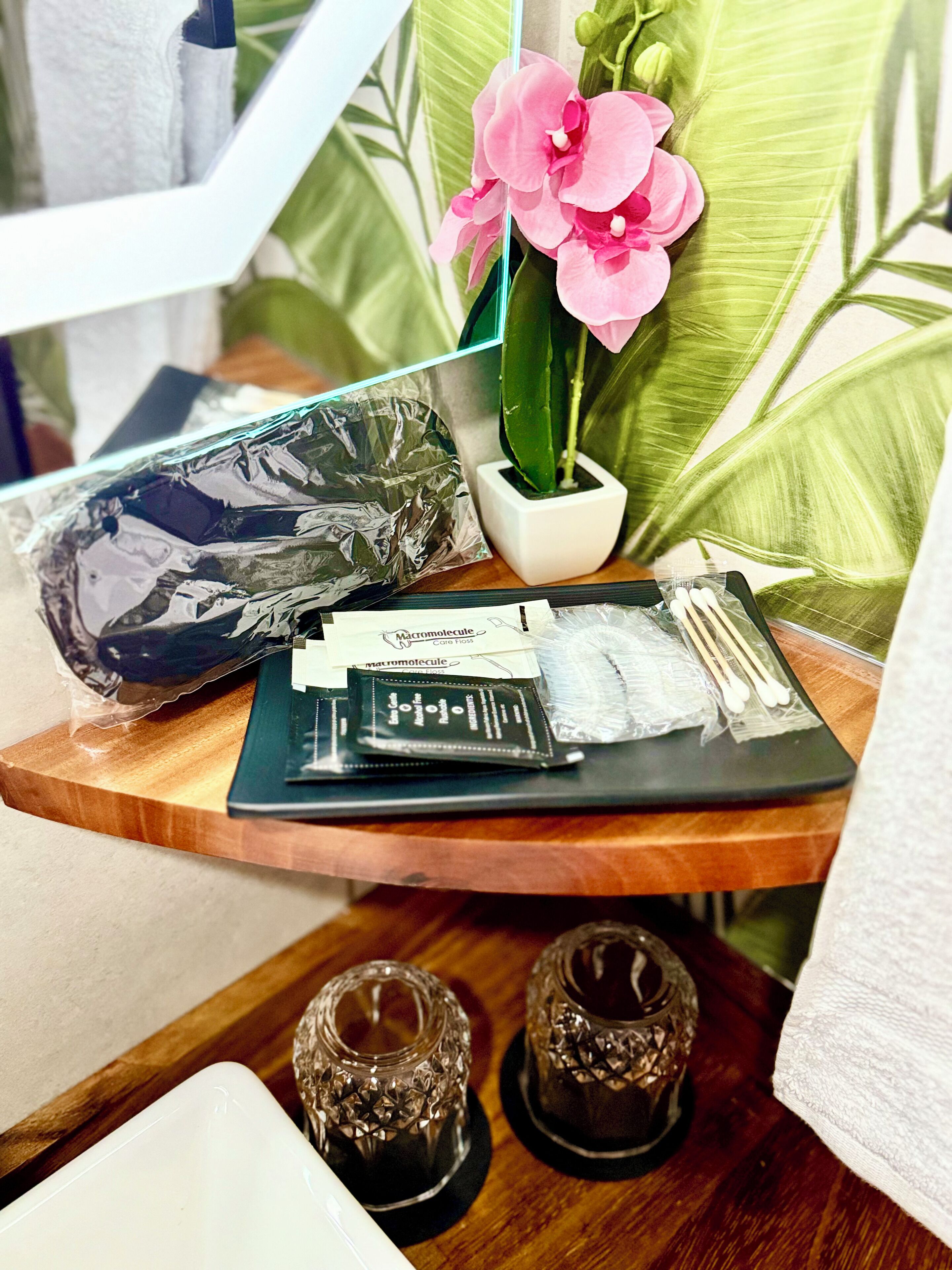 A wooden side table with a potted orchid, a tissue box, and a small decorative item.
