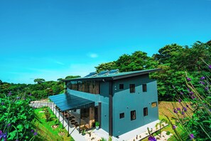 A modern two-story house with a flat roof, large windows, and a covered patio area. - Biofilia Monteverde (Monteverde)