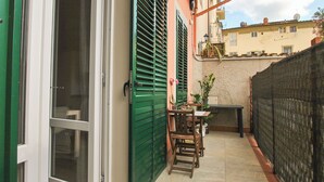 A patio with a table and chairs, a door, and a welcome mat. - Victory Suite, quiet a few minutes from downtown, with private parking (Firenze)