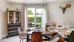 A dining area with a large table set for six, a cabinet with glass doors, and a bull skull decoration on the wall.