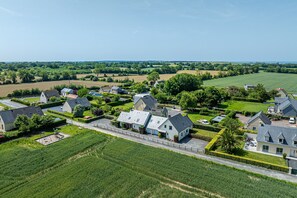 Zona residencial con casas, un parque infantil y un amplio campo verde.