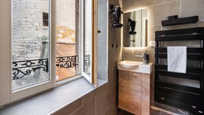 A modern bathroom with a window, a sink, and a towel rack. - La Suite de la Craffe - Vieille ville de Nancy (Nancy)