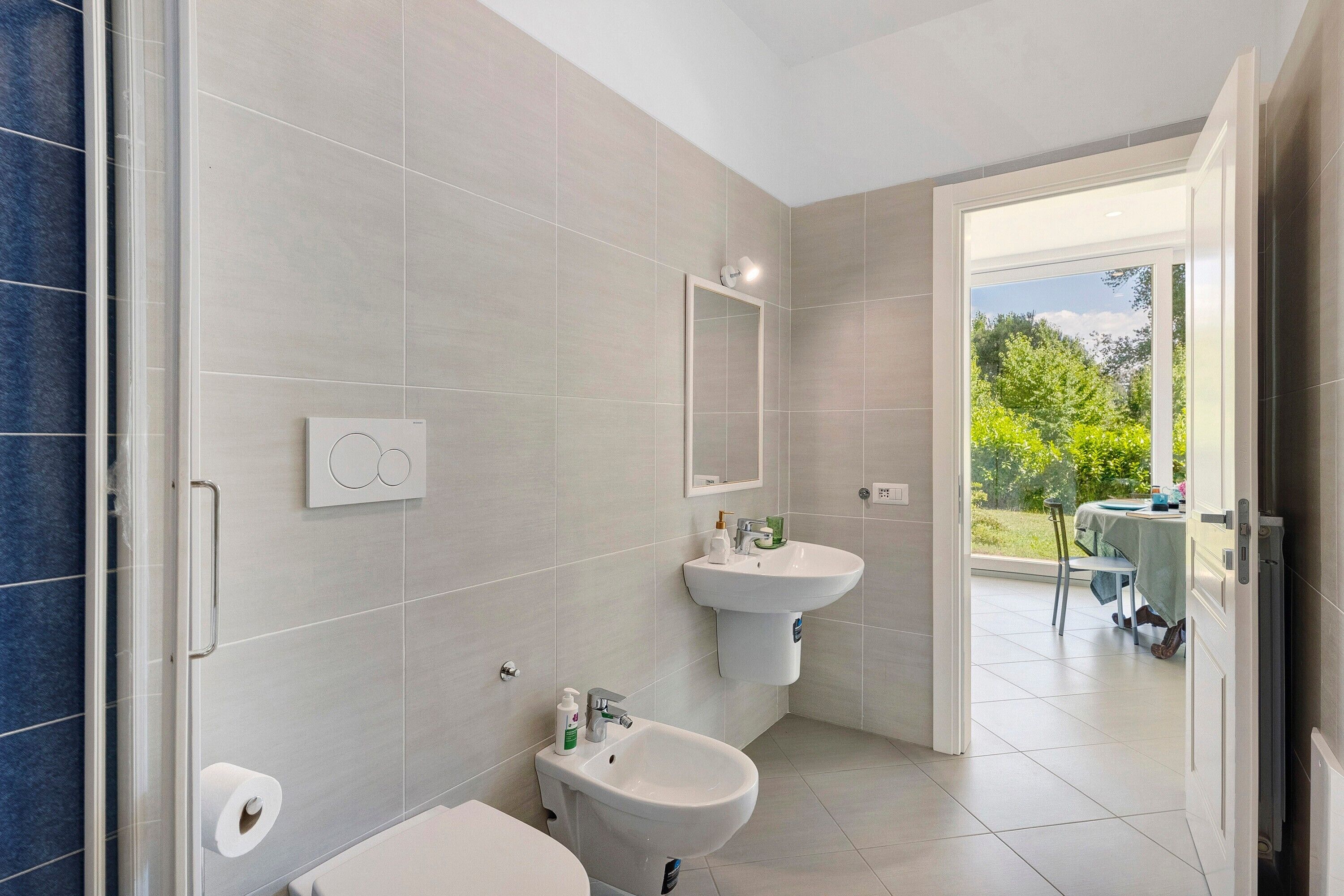 Un baño moderno con inodoro, bidé y lavamanos.