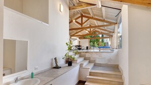A modern bathroom with a large mirror, a sink, and a staircase leading to an upper level. - Apartment 2 with Lake View (Alvignano)