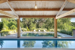 A covered swimming pool with a wooden ceiling, surrounded by greenery and a clear view of the outdoors. - Apartment 2 with Lake View (Alvignano)