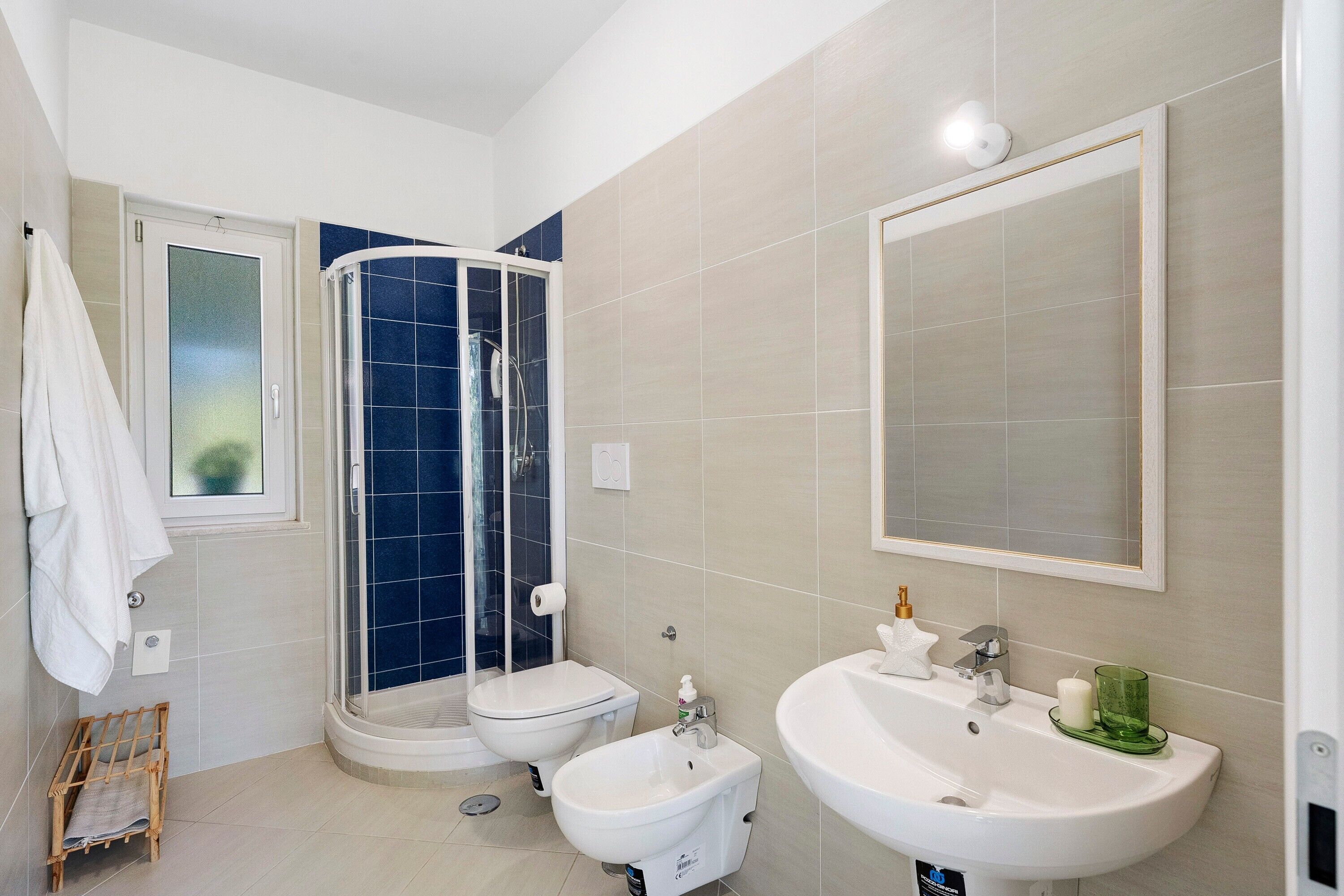 A bathroom with a shower, bidet, and sink.