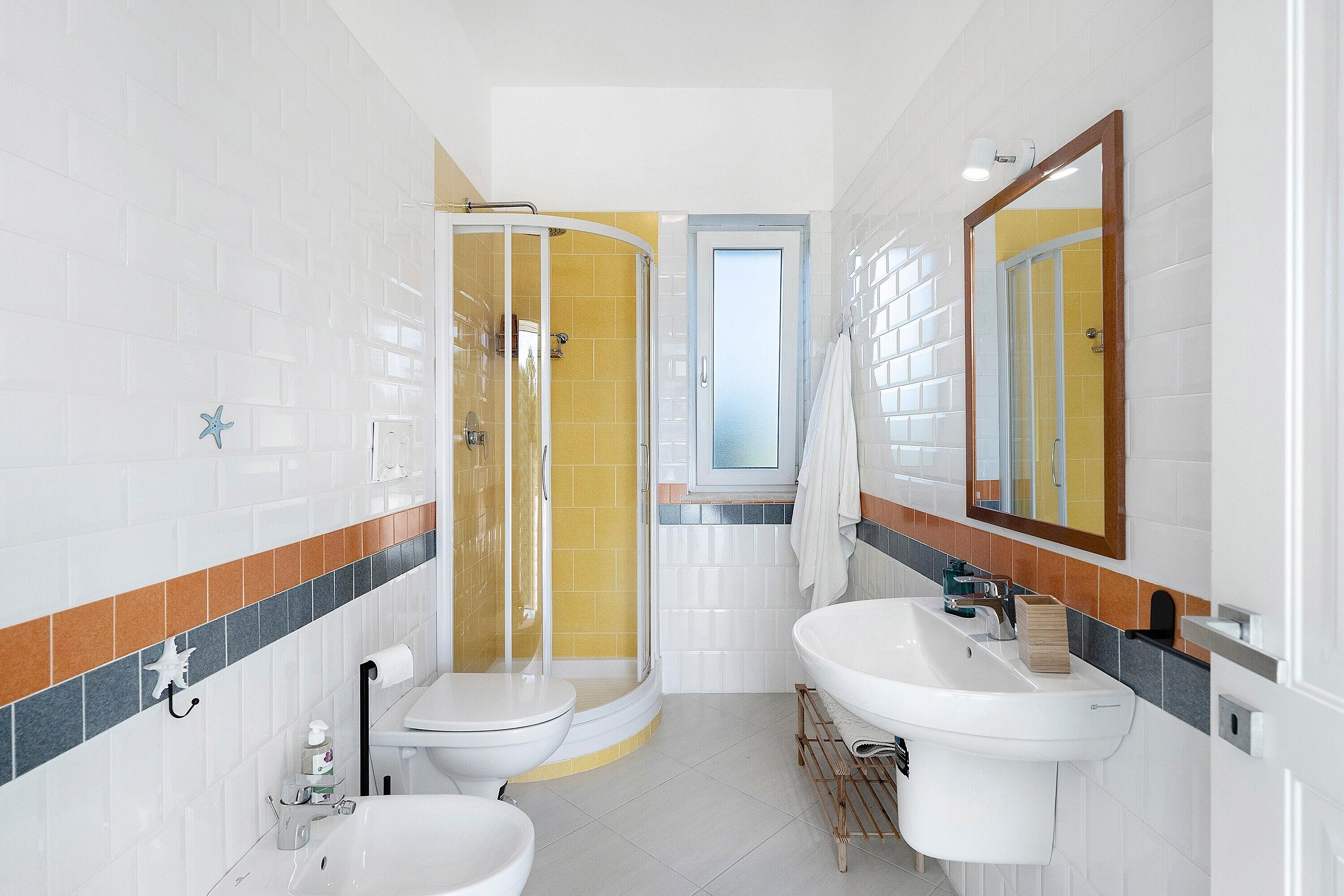 A bathroom with a shower, two sinks, and a toilet.