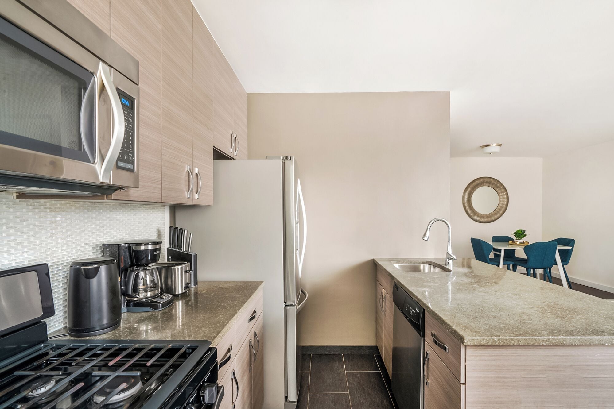 A modern kitchen with a stove, microwave, refrigerator, and dishwasher.