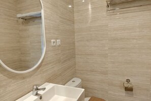 Een badkamer met een wastafel, toilet en spiegel.