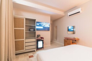 A hotel room with a bed, a wardrobe, a small fridge, a television, and a mirror. - JEMAA EL FNA Suites & Spa (Marrakech)