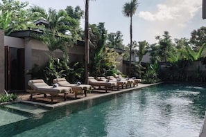 Un espace aménagé au bord de la piscine, avec des chaises longues et une piscine à eau claire.