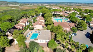 Une vue aérienne d’un quartier résidentiel avec de nombreuses maisons, une piscine et une vue dégagée sur la campagne environnante.