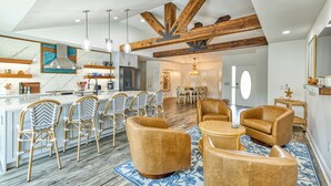 Una cocina amplia con electrodomésticos modernos, un comedor con mobiliario de mimbre y una sala de estar con sofás de cuero.