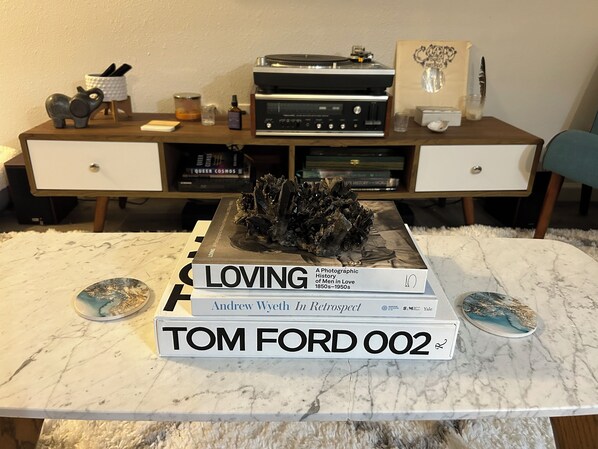 A marble table with books, a crystal sculpture, and a record player.
