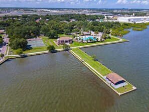 An aerial view of a waterfront property with a basketball court, a pool, and a small building. - Pool, Waterfront Community, Palmetto Beach Compound #1 (Tampa)