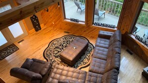 Ein Holzinterieur mit einer Couch, Sesseln und einem Couchtisch.