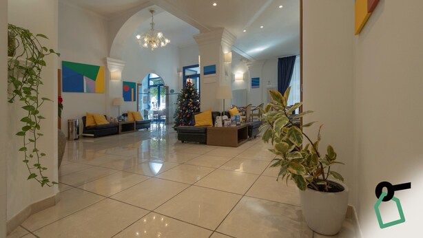Eine geräumige Lobby mit Weihnachtsbaum, Sitzgelegenheiten und einer großen Pflanze in einem Topf.