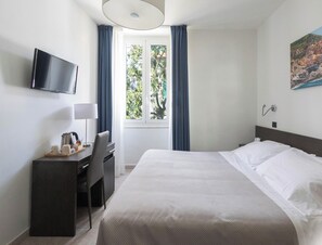 A hotel room with a bed, a desk, a chair, a television mounted on the wall, and a window with curtains. -  Hotiday La Spezia Centrale (La Spezia)