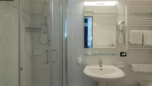 A modern bathroom with a glass shower enclosure, a white sink, and a hairdryer mounted on the wall. -  Hotiday La Spezia Centrale (La Spezia)