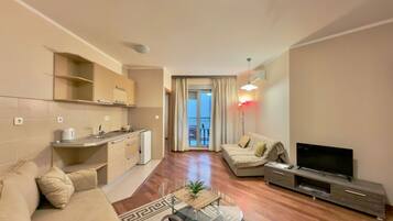 Departamento estándar, balcón, vista a la ciudad | Área de sala de estar | Televisión de pantalla plana