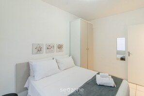 A neatly arranged bedroom with a bed, a wardrobe, and wall art. - Apt With A/C 350m From the Beach in BC Esf0203 (Balneário Camboriú)