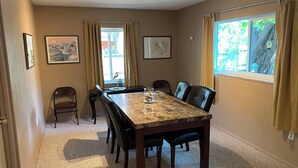 Uma sala de conferências com uma mesa comprida, cadeiras e piso coberto por carpete.
