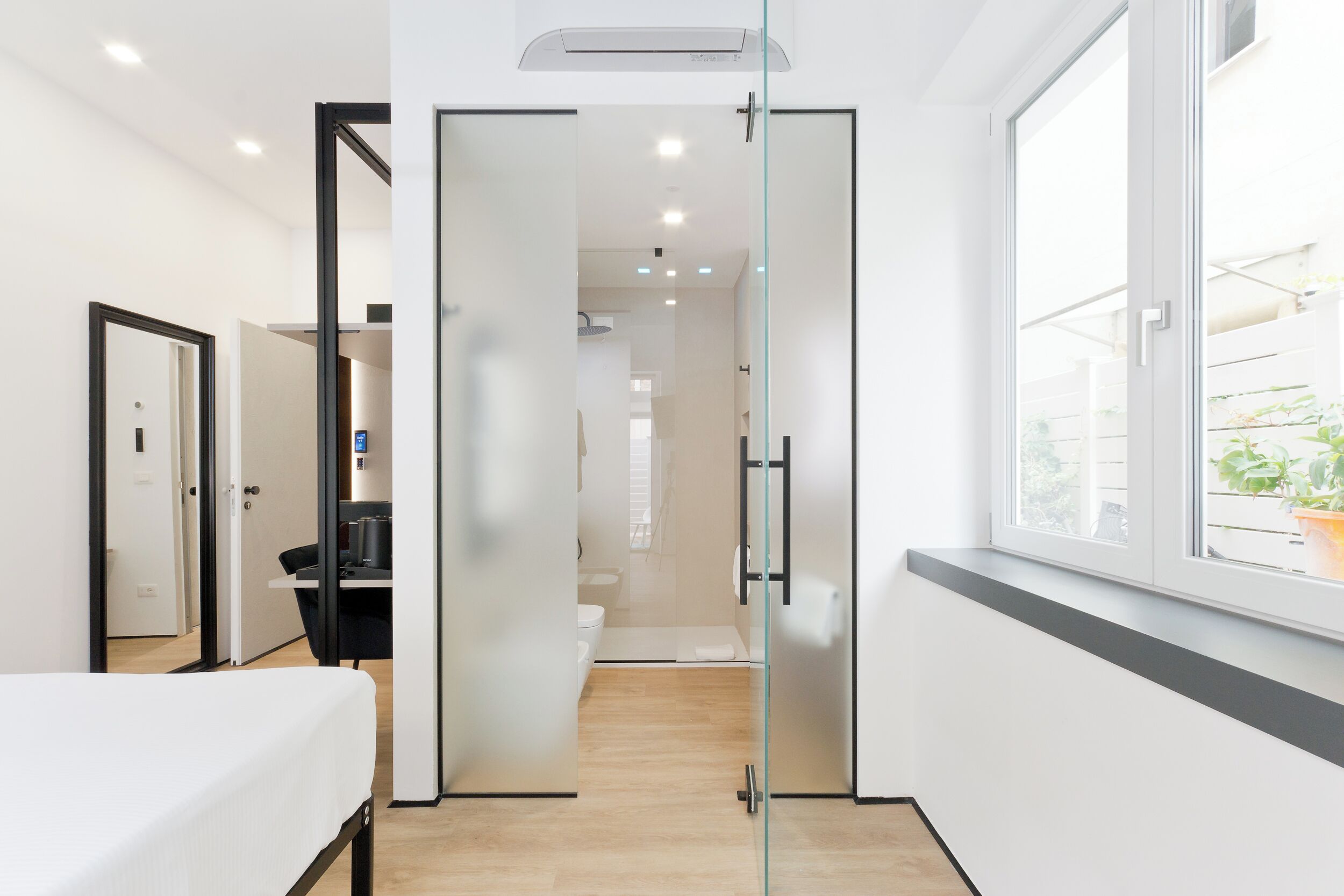 Une salle de bain moderne avec une porte de douche en verre, des toilettes et un lavabo.