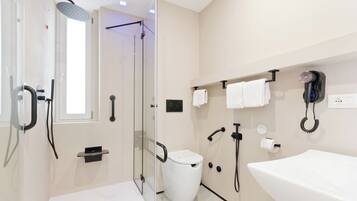 Une salle de bain moderne avec une douche à parois de verre, un lavabo blanc et des toilettes.