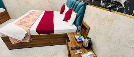 A modern hotel room with a bed, wooden nightstand, and marble walls.