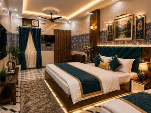Ein Hotelzimmer mit einem großen Bett, einem Deckenventilator, einem Fernseher und einem Badezimmer mit Dusche und Toilette.