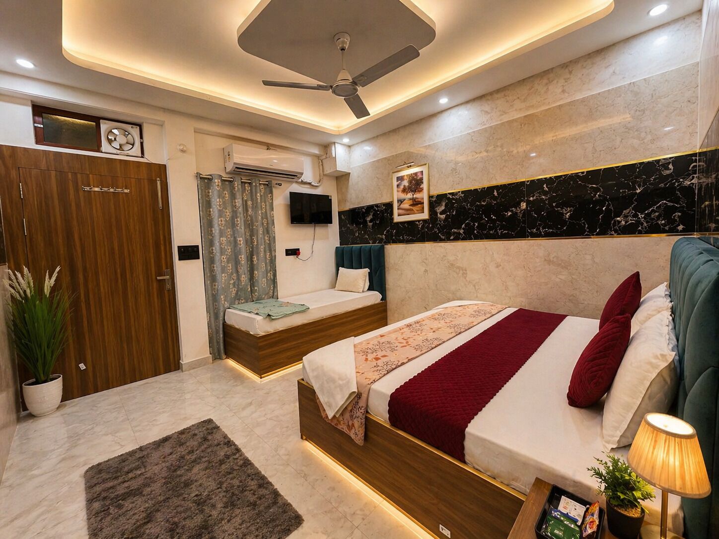 A modern hotel room with a bed, a desk, a ceiling fan, and a TV.