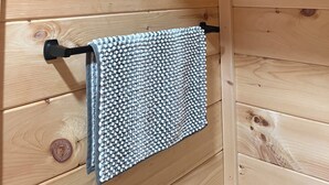 A wooden interior with a towel hanging on a black towel rack. - Charming cabin in Brushton NY. Unit 9 (Brushton)