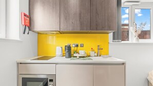A compact kitchen with a microwave, coffee maker, and a small sink. - Contemporary Comfort Steps from Ricoh Arena (Coventry)