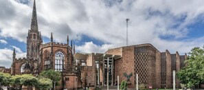 La cathédrale de Coventry, avec son extension moderne, son clocher imposant et un ciel dégagé.