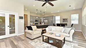 A spacious living room with a beige sofa, a coffee table, and a ceiling fan. - Downtown Tomball-Built in 2025, King Bed, Sleeps 6 (Tomball)