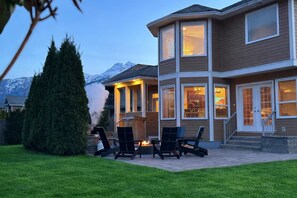 A two-story house with a patio, outdoor seating, and a fireplace. - Premier host-4BR/HotTub/Sauna/Massage Chairs (Revelstoke)