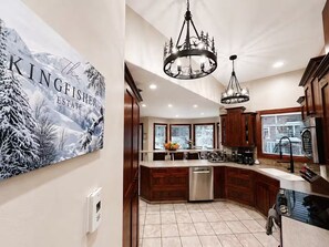 A modern kitchen with wooden cabinets, a stainless steel dishwasher, and a large island.