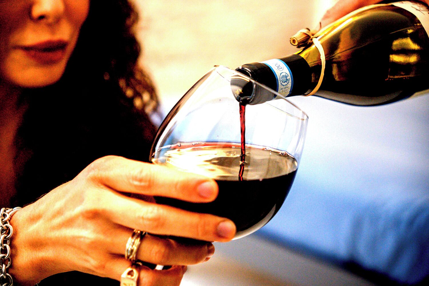 Una persona sirviendo vino en una copa.