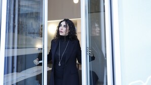 A person standing at a glass door with a light fixture above. - OkHome (Pescara)