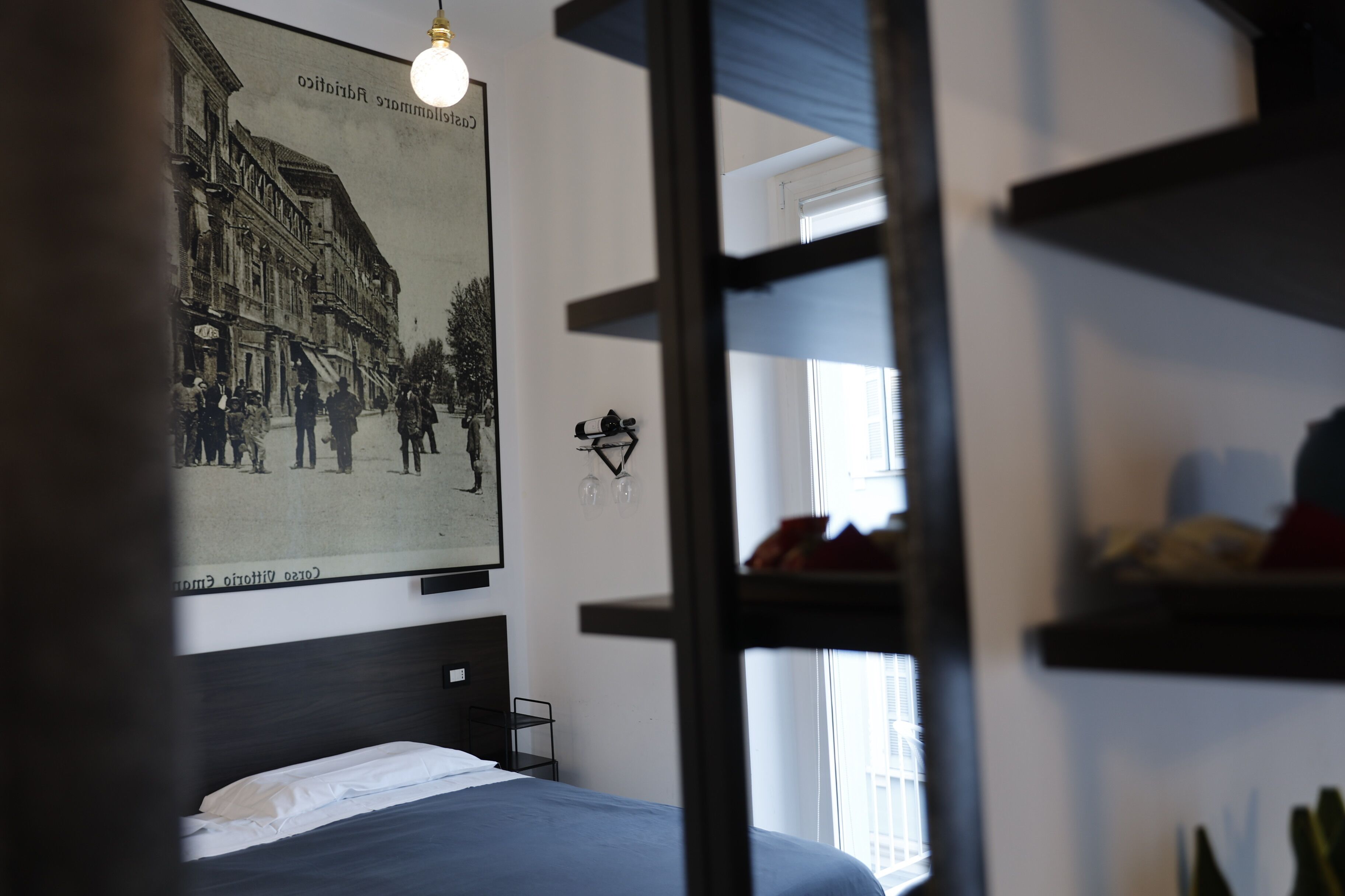 Una habitación de hotel con una cama, un cartel en la pared y una ventana.