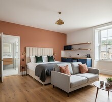Un dormitorio moderno con una cama, un sofá gris y una mesita.