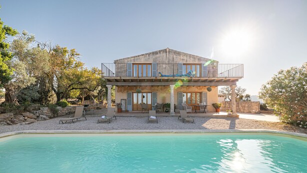 A two-story house with a pool in front.