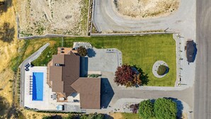 An aerial view of a residential property with a swimming pool, a driveway, and a well-maintained lawn. - Summit Ridge - Lake Chelan & Mountain Views (Manson)