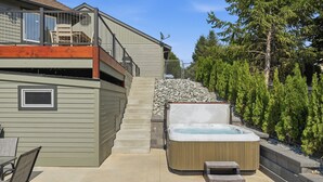 A two-story house with a hot tub, outdoor seating, and a stone retaining wall. - Summit Ridge - Lake Chelan & Mountain Views (Manson)