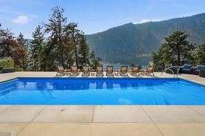 Una piscina con lettini e vista sulle montagne.