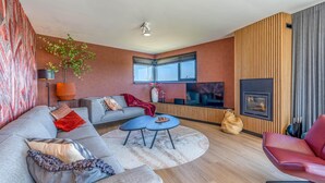 Un salon moderne avec un canapé, une table basse et une cheminée.