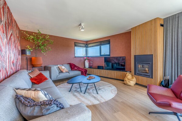 A modern living room with a sofa, coffee table, and a fireplace.