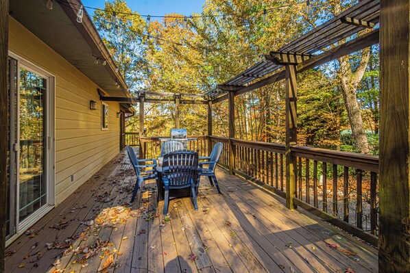 A wooden deck with a pergola, outdoor seating, and a view of autumn trees. - Mountain View Escape-Dog friendly, Screened Porch (Dahlonega)